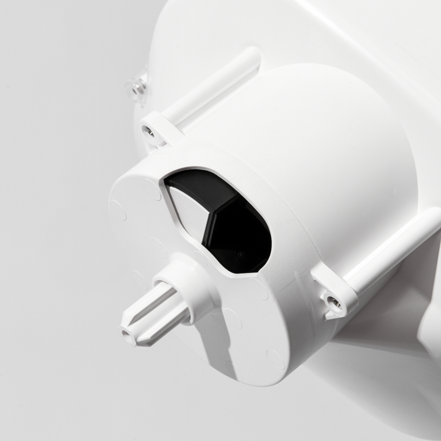 Close-up of a white and black kitchen mixer attachment on a light gray background