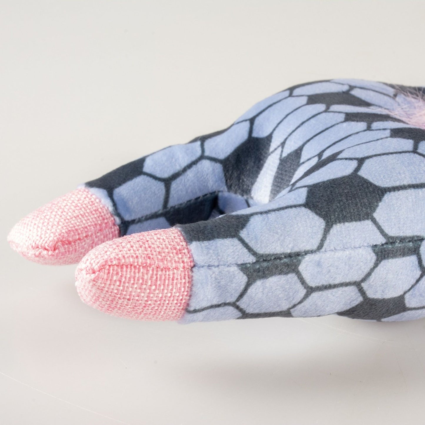 Pair of socks with a geometric pattern and pink toes on a light grey background