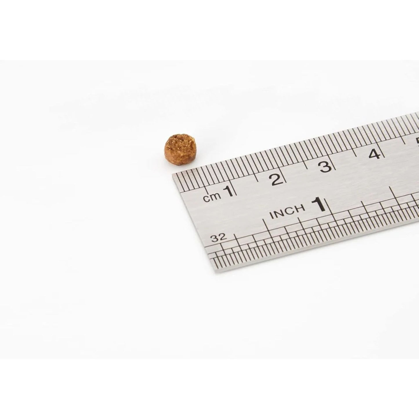 Small cork ball next to a ruler on a white background