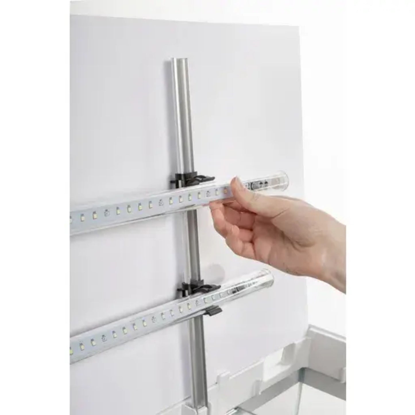 Hand holding a metal rod against a white background