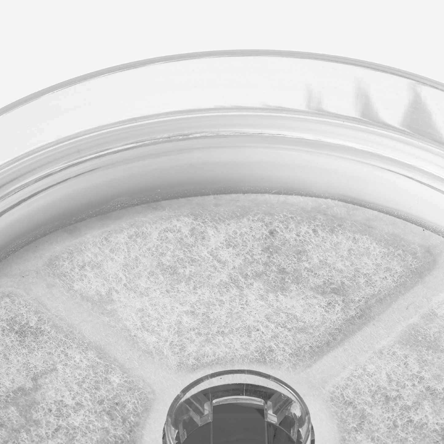 Close-up of a glass container with a textured surface on a white background