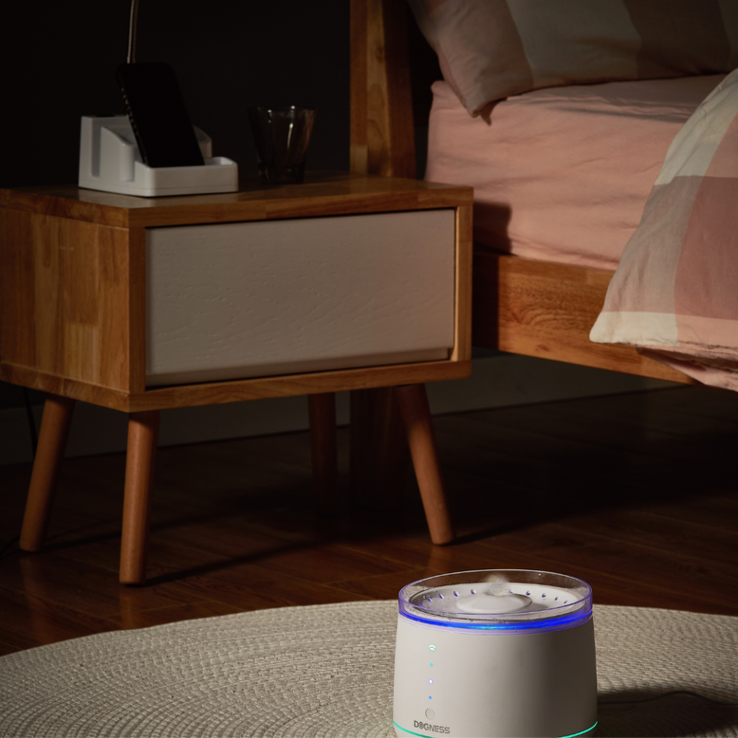 White humidifier on a nightstand in a bedroom setting