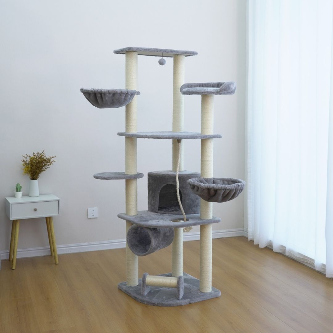 Cat tree with multiple levels and platforms in a room with a small table and plant.