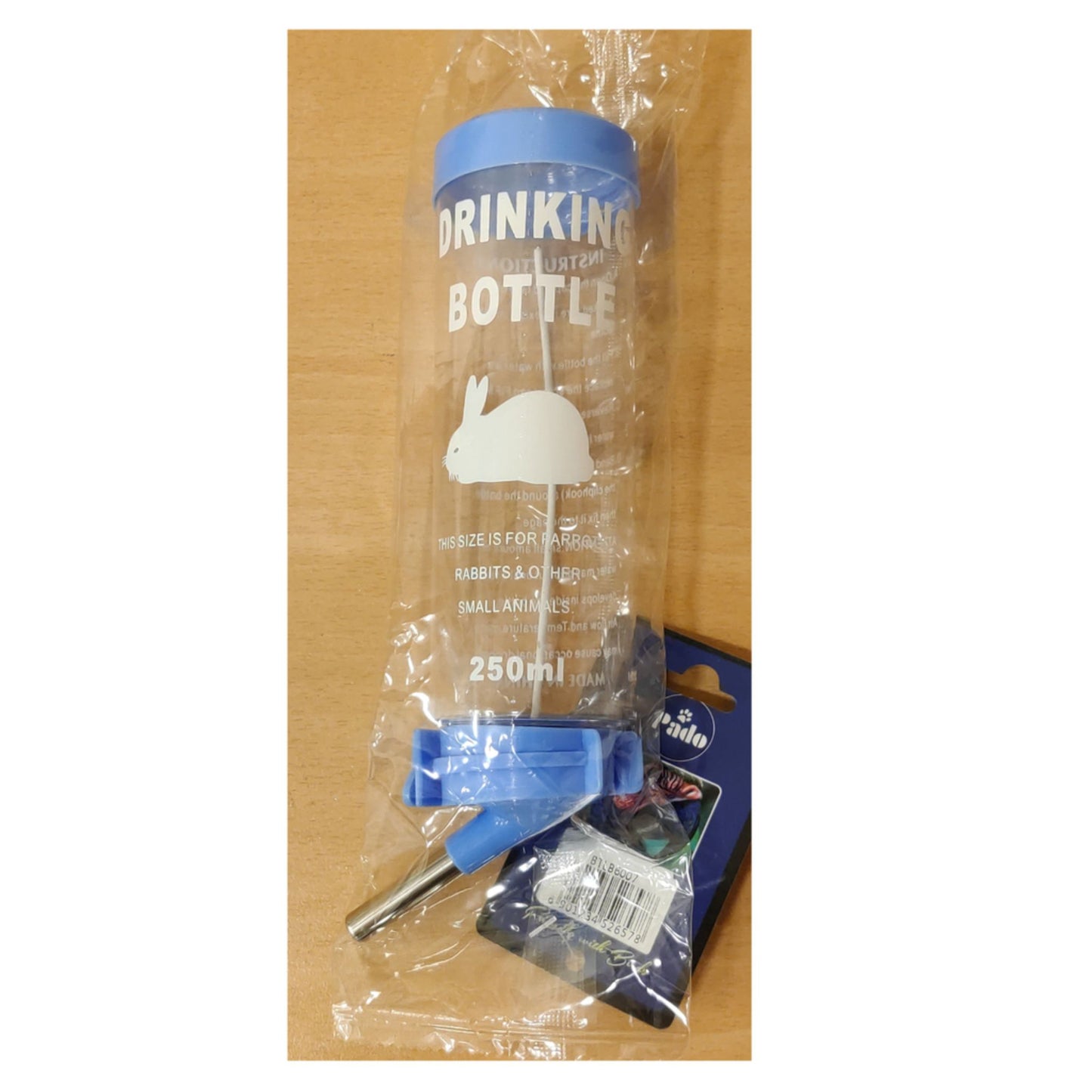Clear drinking bottle with blue cap and label on a wooden surface