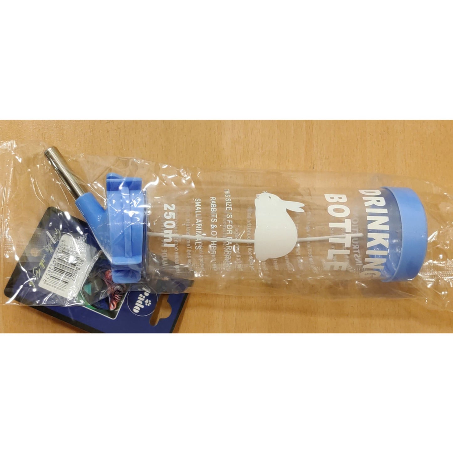 Plastic drinking bottle with blue cap and label on a wooden surface