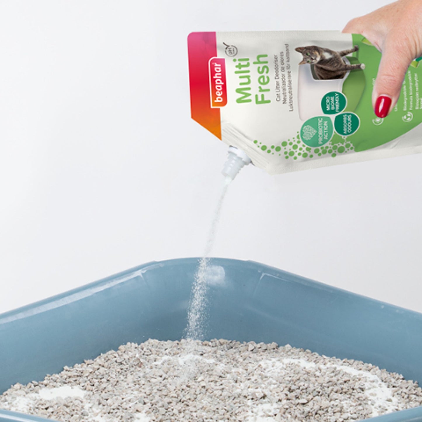 Bephar Multi Fresh cat litter being poured into a blue litter box.